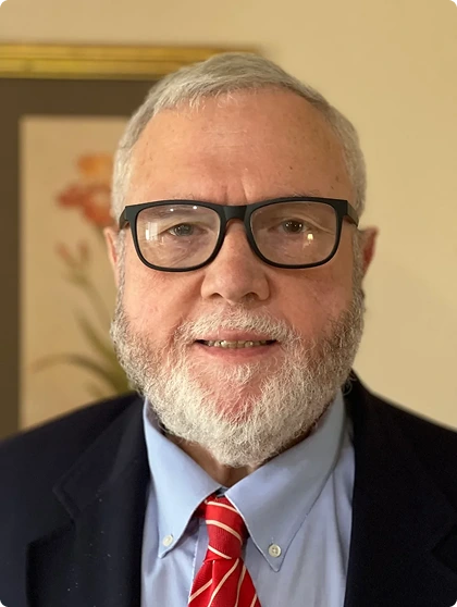 A portrait of Attorney James Bendell, featuring glasses and a striking red tie
